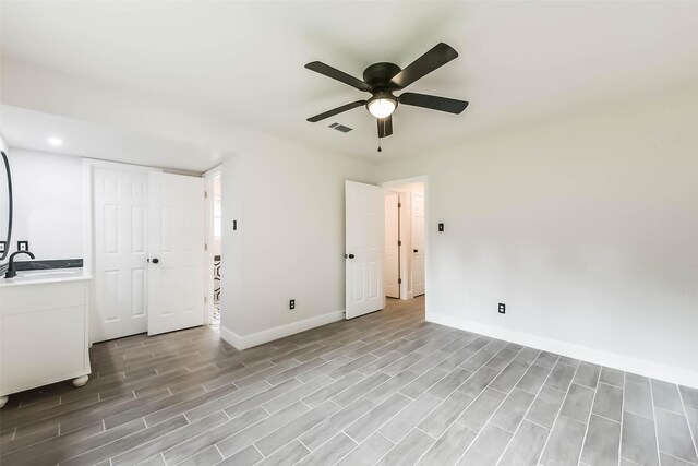 9096 N Comanche Cir, Willis, TX 77378 - empty room featuring a sink, a ceiling fan, baseboards, light wood-style floors, and recessed lighting