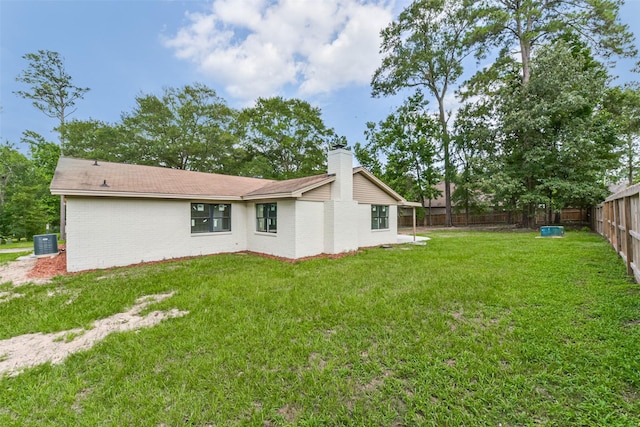 9096 N Comanche Cir, Willis, TX 77378 - rear view of property featuring central air condition unit, brick siding, and a chimney