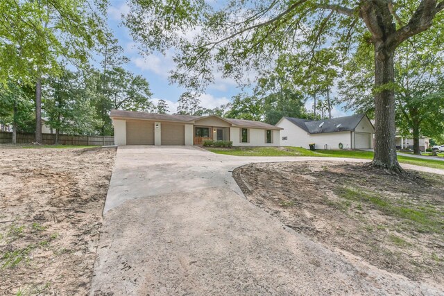9096 N Comanche Cir, Willis, TX 77378 - ranch-style house featuring a garage, concrete driveway, and stucco siding