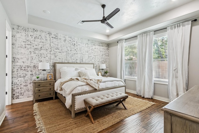 1935 Invermere Dr, Spring, TX 77386 - bedroom with an accent wall, dark wood-style floors, a tray ceiling, and ceiling fan