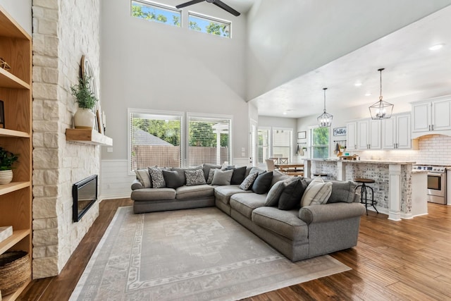 1935 Invermere Dr, Spring, TX 77386 - living area with dark wood-style floors, a wainscoted wall, a fireplace, a high ceiling, and recessed lighting