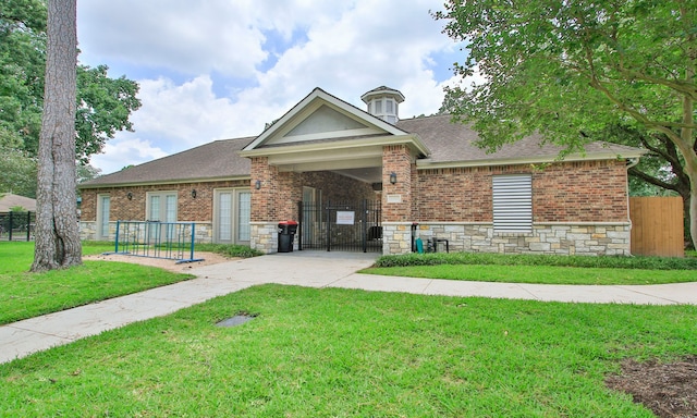 1935 Invermere Dr, Spring, TX 77386 - view of front facade featuring a gate, a shingled roof, brick siding, and stone siding