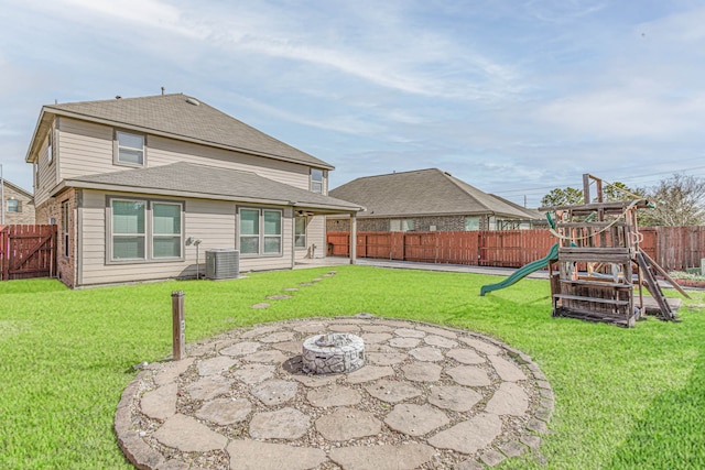 13018 Foxwood Creek Ln, Houston, TX 77044 - back of house featuring a playground, a patio area, central AC unit, an outdoor fire pit, and roof with shingles