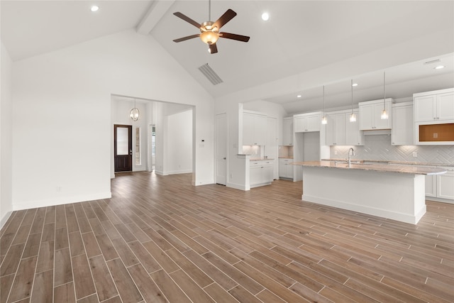 18232 Saffron Sun St, Conroe, TX 77302 - unfurnished living room with beam ceiling, ceiling fan, a sink, high vaulted ceiling, and light wood finished floors