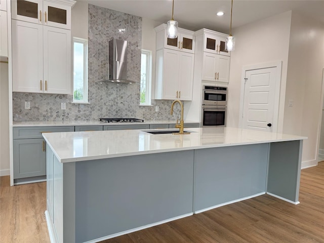 1307 71st St Unit A, Houston, TX 77011 - kitchen with wall chimney range hood, light wood finished floors, appliances with stainless steel finishes, backsplash, and recessed lighting