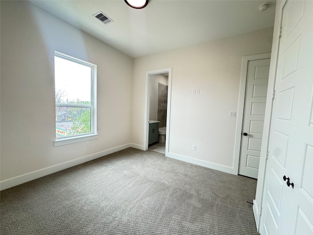 1307 71st St Unit A, Houston, TX 77011 - unfurnished bedroom featuring baseboards, dark carpet, and ensuite bathroom