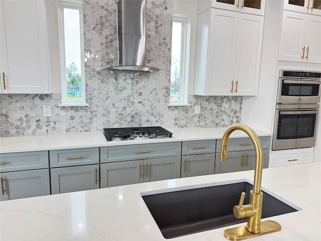 1307 71st St Unit A, Houston, TX 77011 - kitchen with stainless steel appliances, wall chimney range hood, glass insert cabinets, and decorative backsplash