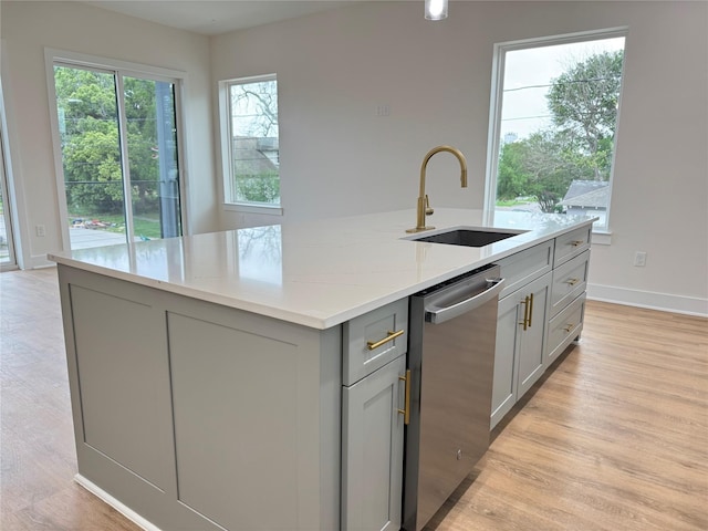 1307 71st St Unit A, Houston, TX 77011 - kitchen featuring gray cabinets, dishwasher, a sink, an island with sink, and light stone counters