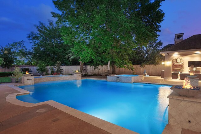 7 Spindrift Pl, The Woodlands, TX 77381 - view of pool featuring an in-ground hot tub, a patio, a fenced backyard, a fire pit, and a lit fireplace