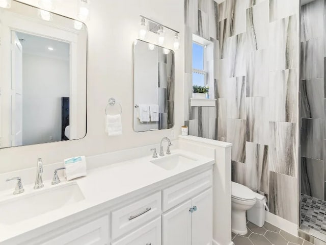 22906 Miramar St, Galveston, TX 77554 - full bathroom with toilet, double vanity, a tile shower, and tile patterned flooring