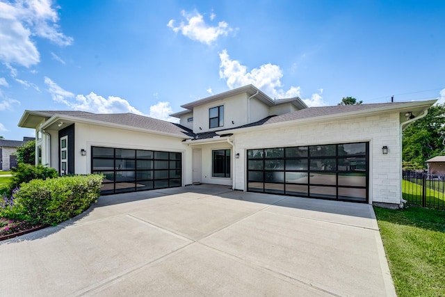 1002 Royal Lakes Manor Blvd, Richmond, TX 77469 - modern home with stucco siding, an attached garage, and driveway