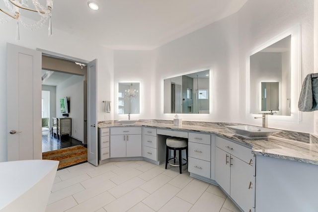 1002 Royal Lakes Manor Blvd, Richmond, TX 77469 - full bathroom featuring a chandelier, double vanity, a freestanding tub, and tile patterned flooring