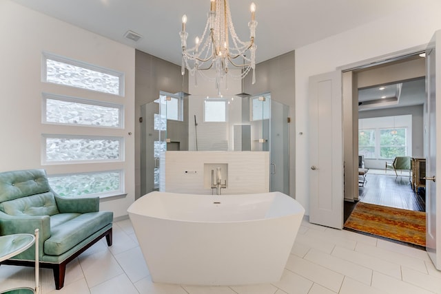 1002 Royal Lakes Manor Blvd, Richmond, TX 77469 - bathroom featuring a chandelier, a soaking tub, a stall shower, and tile patterned flooring