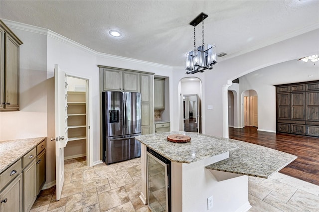 21814 Canton Pass Ln, Katy, TX 77450 - kitchen featuring stainless steel refrigerator with ice dispenser, arched walkways, wine cooler, ornamental molding, and a center island