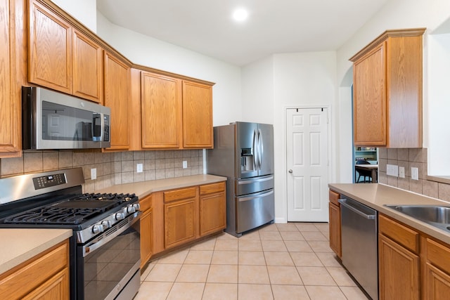 4613 Meridian Park Dr, Pearland, TX 77584 - kitchen with stainless steel appliances, tasteful backsplash, light tile patterned floors, light countertops, and a sink