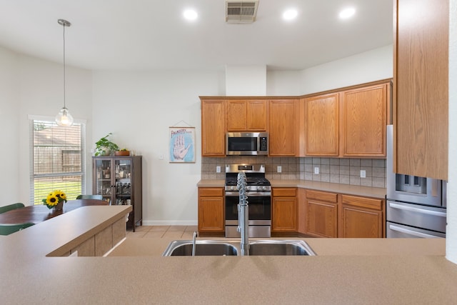 4613 Meridian Park Dr, Pearland, TX 77584 - kitchen with appliances with stainless steel finishes, backsplash, decorative light fixtures, baseboards, and light tile patterned flooring