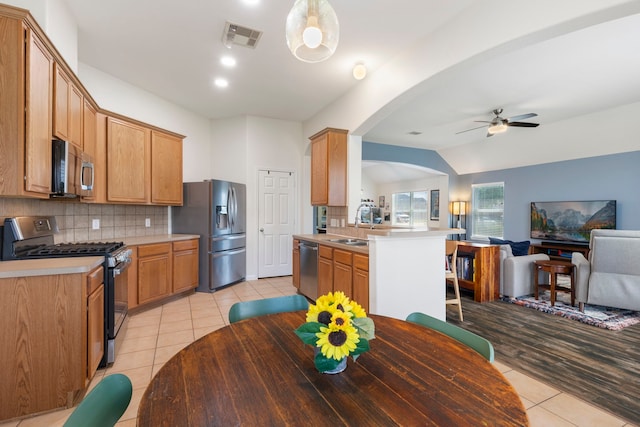 4613 Meridian Park Dr, Pearland, TX 77584 - kitchen featuring stainless steel appliances, light tile patterned floors, open floor plan, a ceiling fan, and backsplash