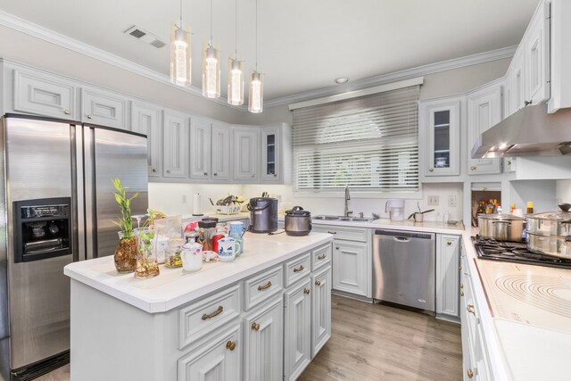 548 Cascade St, Bellaire, TX 77401 - kitchen with appliances with stainless steel finishes, a sink, under cabinet range hood, ornamental molding, and a kitchen island