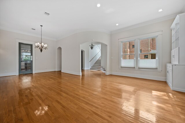 940 Columbia St, Houston, TX 77008 - unfurnished living room with arched walkways, light wood finished floors, a chandelier, crown molding, and baseboards