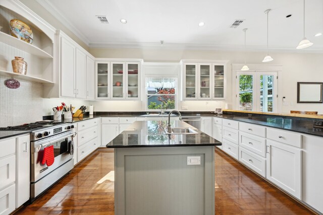 940 Columbia St, Houston, TX 77008 - kitchen featuring stainless steel gas range, a sink, crown molding, glass insert cabinets, and hanging light fixtures