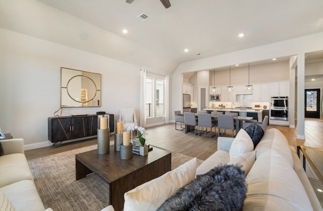 19318 Stagecoach Breeze Ln, Tomball, TX 77377 - living area featuring light wood-style floors, baseboards, ceiling fan, recessed lighting, and lofted ceiling