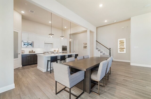 19318 Stagecoach Breeze Ln, Tomball, TX 77377 - dining space featuring light wood-style flooring, stairway, baseboards, and recessed lighting