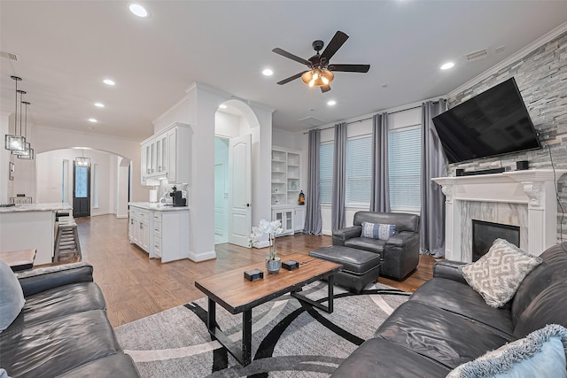 1035 Herkimer St, Houston, TX 77008 - living area featuring arched walkways, ceiling fan, light wood finished floors, recessed lighting, and a large fireplace