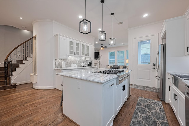 1035 Herkimer St, Houston, TX 77008 - kitchen featuring appliances with stainless steel finishes, dark wood finished floors, a kitchen island, white cabinetry, and a ceiling fan