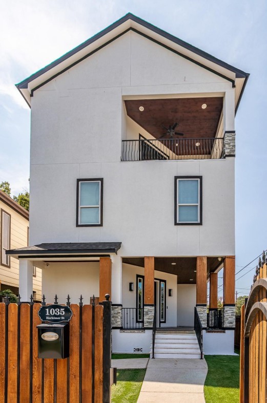 1035 Herkimer St, Houston, TX 77008 - view of front of property featuring stucco siding, a balcony, covered porch, and stone siding