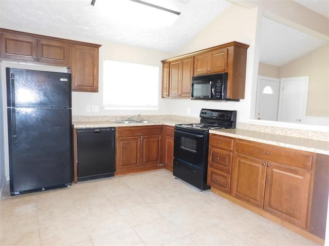17002 Rippling Mill Dr, Sugar Land, TX 77498 - kitchen featuring black appliances, vaulted ceiling, a sink, light countertops, and brown cabinetry