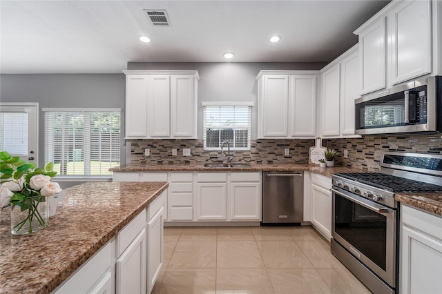 14619 Sanour Dr, Houston, TX 77084 - kitchen featuring stainless steel appliances, a sink, backsplash, white cabinetry, and recessed lighting