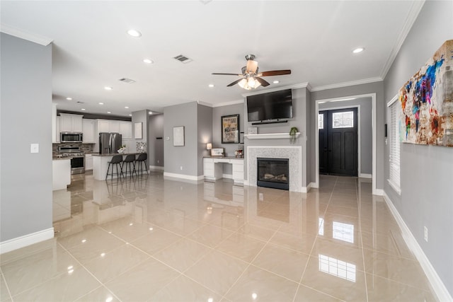 14619 Sanour Dr, Houston, TX 77084 - living area featuring light tile patterned floors, baseboards, ceiling fan, ornamental molding, and recessed lighting