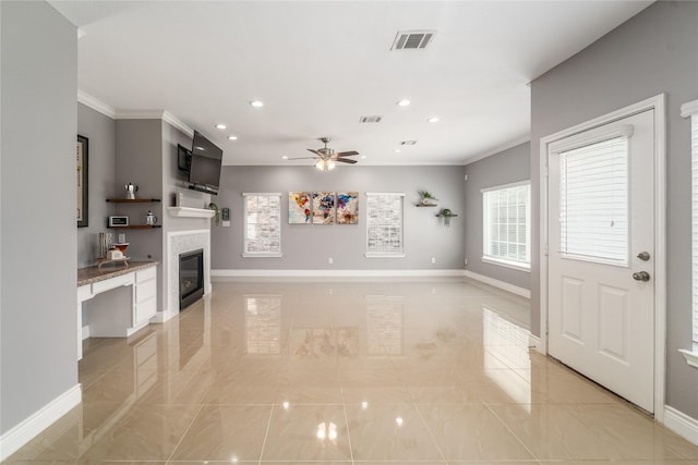 14619 Sanour Dr, Houston, TX 77084 - unfurnished living room featuring crown molding, ceiling fan, recessed lighting, light tile patterned flooring, and a glass covered fireplace