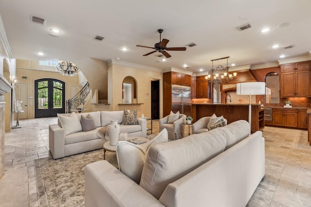 4922 Linden St, Bellaire, TX 77401 - living room with stone tile flooring, ornamental molding, recessed lighting, ceiling fan, and a chandelier