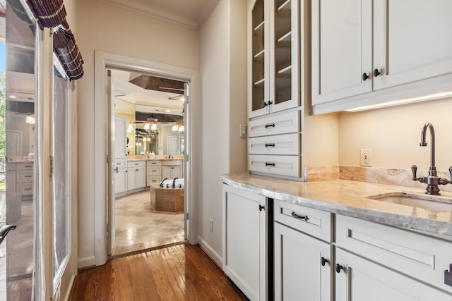4922 Linden St, Bellaire, TX 77401 - bar with ornamental molding, a sink, dark wood finished floors, and baseboards