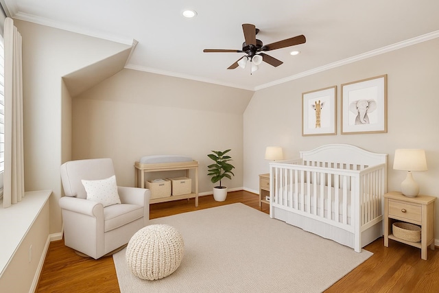 4922 Linden St, Bellaire, TX 77401 - bedroom featuring wood finished floors, crown molding, baseboards, recessed lighting, and a nursery area