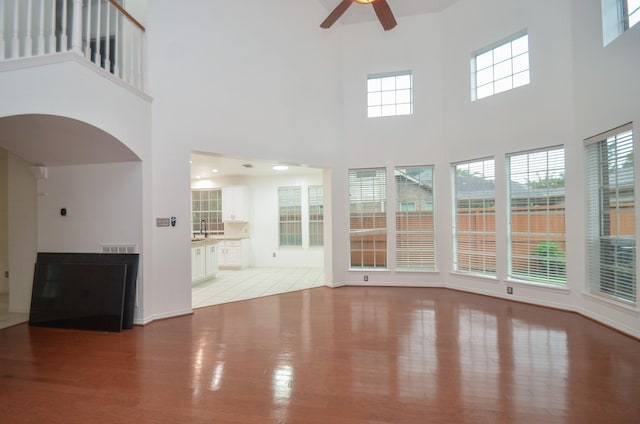5319 Green Cove Bend Ln, Houston, TX 77041 - unfurnished living room featuring light wood-style floors, a ceiling fan, a high ceiling, and plenty of natural light