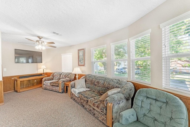 210 W Lakeview, Onalaska, TX 77360 - living area with a textured ceiling, a ceiling fan, carpet flooring, wood walls, and wainscoting