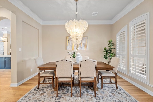 15222 Hilltop View Dr, Cypress, TX 77429 - dining space with a chandelier, light wood-style flooring, arched walkways, and ornamental molding