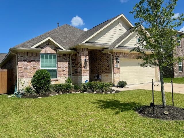 10809 Mendel Terrace Dr, Rosharon, TX 77583 - view of front of house with brick siding, a garage, a front lawn, concrete driveway, and roof with shingles