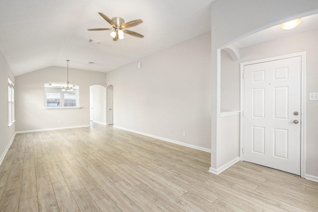 19238 Augusta Mist Ln, Katy, TX 77449 - unfurnished living room featuring arched walkways, a ceiling fan, light wood-type flooring, vaulted ceiling, and a chandelier
