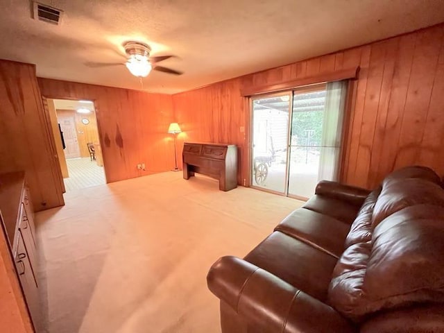 302 Cordell Dr, Crockett, TX 75835 - carpeted living area featuring wood walls and ceiling fan