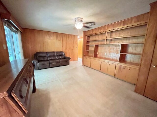 302 Cordell Dr, Crockett, TX 75835 - unfurnished living room featuring wooden walls, ceiling fan, and light carpet