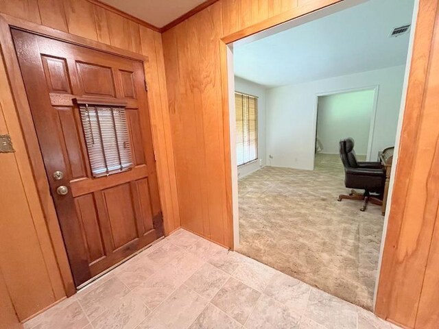 302 Cordell Dr, Crockett, TX 75835 - carpeted entrance foyer with wooden walls and ornamental molding