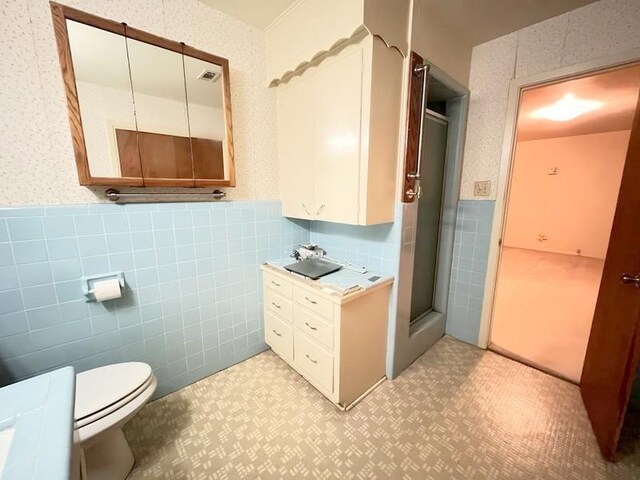 302 Cordell Dr, Crockett, TX 75835 - full bath with tile walls, a wainscoted wall, wallpapered walls, a stall shower, and vanity