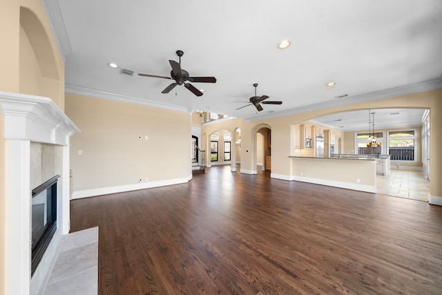 4628 Beech St, Bellaire, TX 77401 - unfurnished living room featuring a fireplace with flush hearth, ceiling fan, ornamental molding, wood finished floors, and baseboards