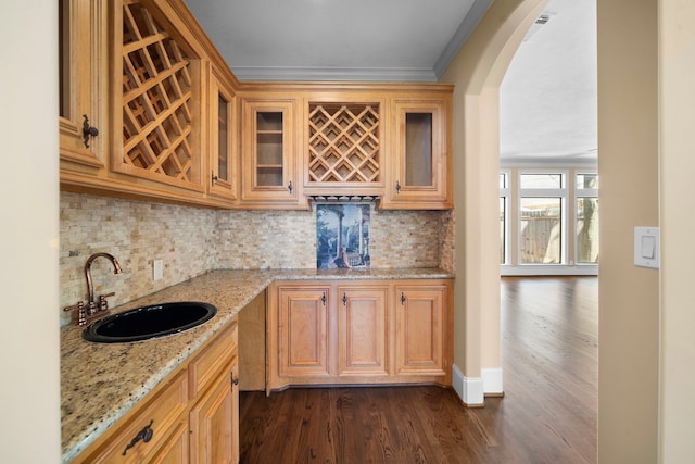 4628 Beech St, Bellaire, TX 77401 - kitchen with a sink, tasteful backsplash, light stone counters, dark wood-type flooring, and ornamental molding
