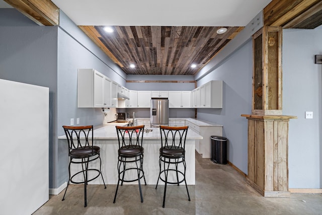 3525 N Morning Glory Dr, Santa Fe, TX 77517 - kitchen with stainless steel fridge with ice dispenser, wooden ceiling, concrete floors, a peninsula, and light countertops