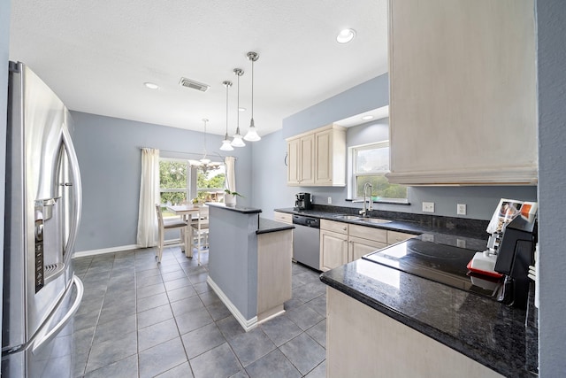 3525 N Morning Glory Dr, Santa Fe, TX 77517 - kitchen with stainless steel appliances, a sink, a kitchen island, a chandelier, and cream cabinets