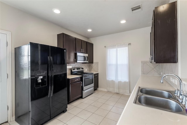 20507 Avery Grove Ct, Cypress, TX 77433 - kitchen featuring stainless steel appliances, a sink, dark brown cabinetry, decorative backsplash, and light countertops